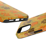 Close-up of yellow phone cases with orange and brown paw prints, showing different cutout sizes