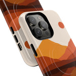 Close-up of two smartphone cases with orange and brown abstract landscape design, showing different sizes