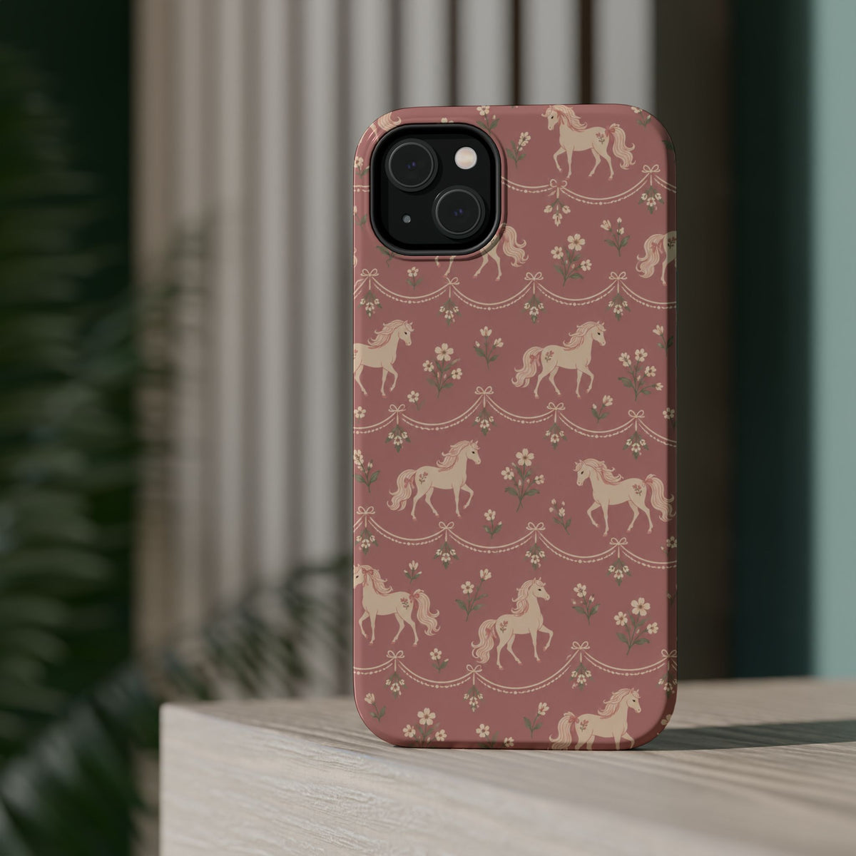 Rose Ponies MagSafe Phone Case, glossy diagonal dual-camera model, rear view on a tabletop