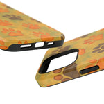 Close-up of two yellow smartphone cases with orange and brown paw print design showing different size variants