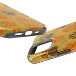 Close-up of phone cases with orange and brown paw print design showing different size variants
