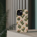 Cactus Bloom – Sage Green Floral Cactus MagSafe Phone Case, glossy diagonal dual-camera model, rear view on a tabletop