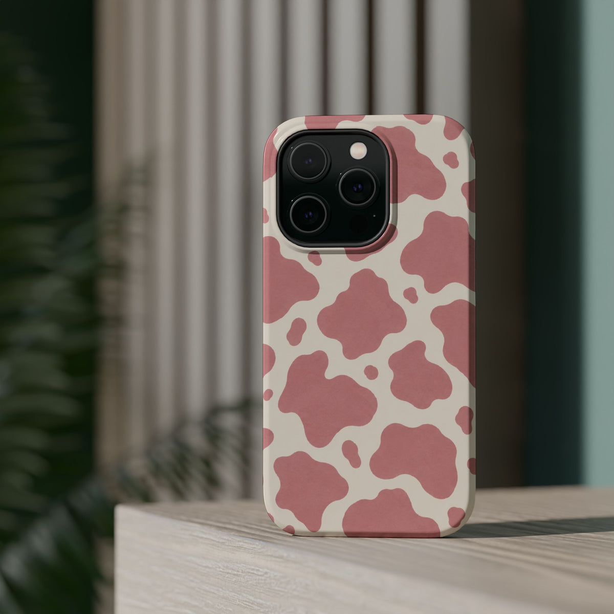 Rose Cowprint – Pink Cow Print MagSafe Phone Case, glossy square triple-camera Pro model, rear view on a tabletop