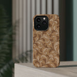 Saddle Scrolls – Tan Western Scrollwork MagSafe Phone Case, glossy square triple-camera Pro model, rear view on a tabletop