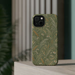 Golden Meadow – Sage Green Wildflower MagSafe Phone Case, glossy diagonal dual-camera model, rear view on a tabletop