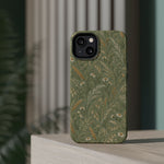 Golden Meadow – Sage Green Wildflower MagSafe Phone Case, glossy diagonal dual-camera model, rear view on a tabletop