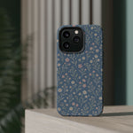 Denim Wildflowers MagSafe Phone Case, glossy square triple-camera Pro model, rear view on a tabletop