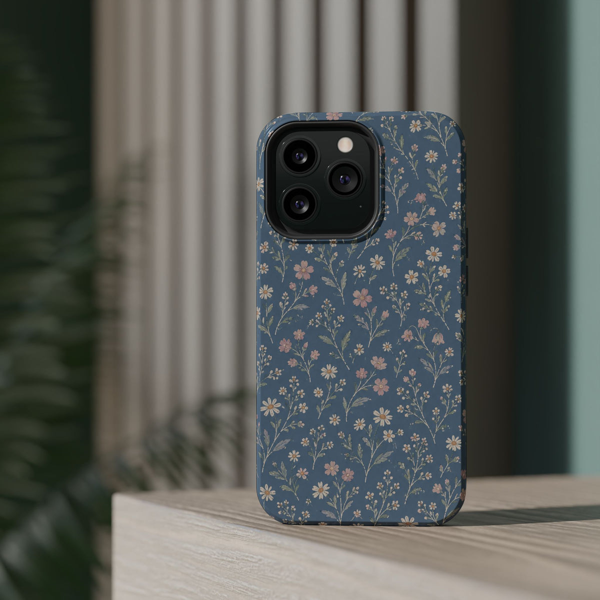 Denim Wildflowers MagSafe Phone Case, glossy square triple-camera Pro model, rear view on a tabletop