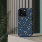 Lasso Hearts – Blue Western Heart MagSafe Phone Case, glossy square triple-camera Pro model, rear view on a tabletop