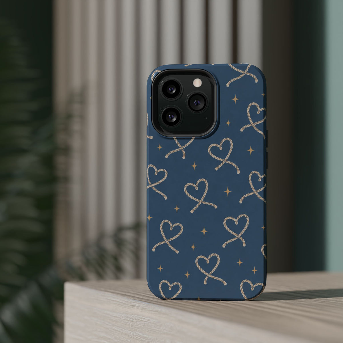 Lasso Hearts – Blue Western Heart MagSafe Phone Case, glossy square triple-camera Pro model, rear view on a tabletop
