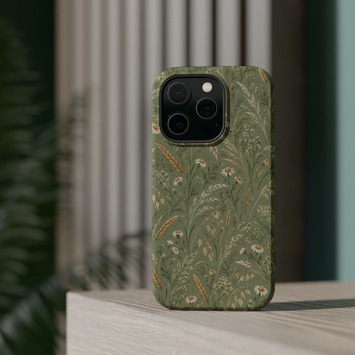 Golden Meadow – Sage Green Wildflower MagSafe Phone Case, glossy square triple-camera Pro model, rear view on a tabletop