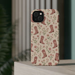 Floral Boots MagSafe Phone Case, glossy diagonal dual-camera model, rear view on a tabletop