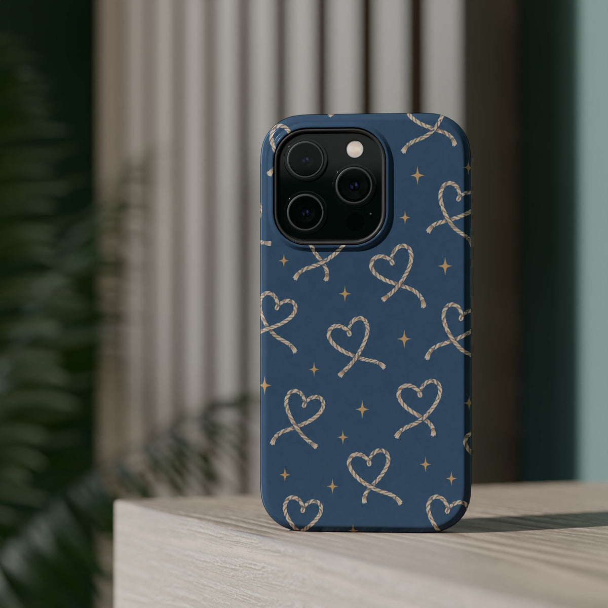 Lasso Hearts – Blue Western Heart MagSafe Phone Case, glossy square triple-camera Pro model, rear view on a tabletop