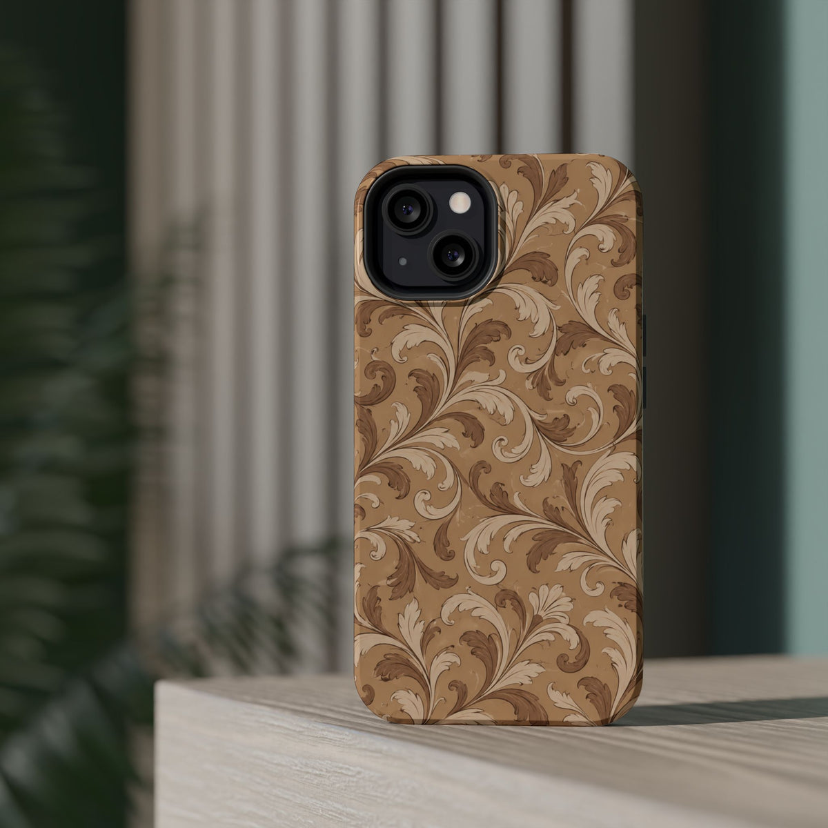 Saddle Scrolls – Tan Western Scrollwork MagSafe Phone Case, glossy diagonal dual-camera model, rear view on a tabletop