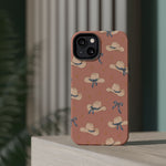 Ribbon Rodeo – Cowgirl Hat and Bow MagSafe Phone Case, Pink, glossy diagonal dual-camera model, rear view on a tabletop