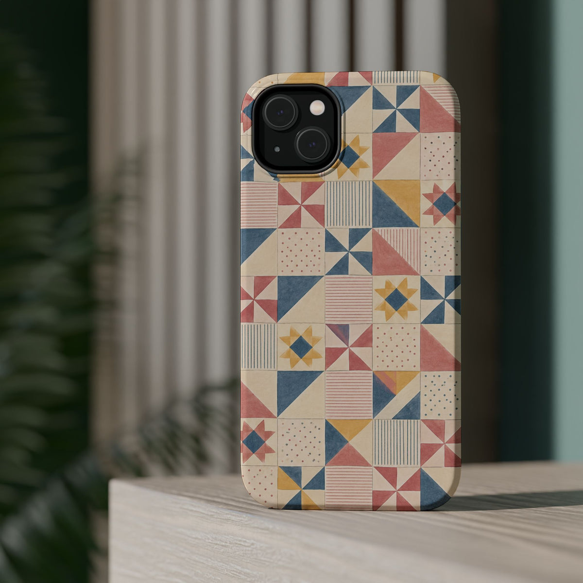 Prairie Quilt – Pastel Patchwork Pattern MagSafe Phone Case, glossy diagonal dual-camera model, rear view on a tabletop