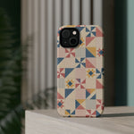 Prairie Quilt – Pastel Patchwork Pattern MagSafe Phone Case, glossy diagonal dual-camera model, rear view on a tabletop