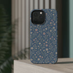 Denim Wildflowers MagSafe Phone Case, glossy square triple-camera Pro model, rear view on a tabletop