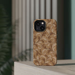 Saddle Scrolls – Tan Western Scrollwork MagSafe Phone Case, glossy diagonal dual-camera model, rear view on a tabletop