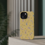 Honey Paisley MagSafe Phone Case, glossy diagonal dual-camera model, rear view on a tabletop