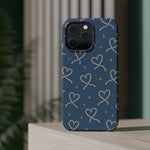 Lasso Hearts – Blue Western Heart MagSafe Phone Case, glossy square triple-camera Pro model, rear view on a tabletop
