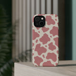 Rose Cowprint – Pink Cow Print MagSafe Phone Case, glossy diagonal dual-camera model, rear view on a tabletop
