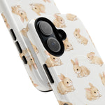 Close-up of phone cases with cute light brown bunny pattern, showing two size variants side by side