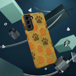 Smartphone case with orange and brown paw prints on yellow background, showing variant size