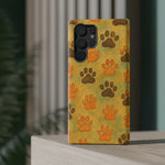 Samsung Galaxy S22 Ultra phone case with brown and orange paw print pattern on yellow background