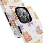 Close-up of two smartphone cases with teddy bear and bow pattern, showing different sizes