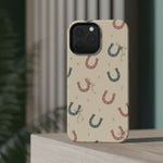 Prairie Horseshoes MagSafe Phone Case, glossy square triple-camera Pro model, rear view on a tabletop