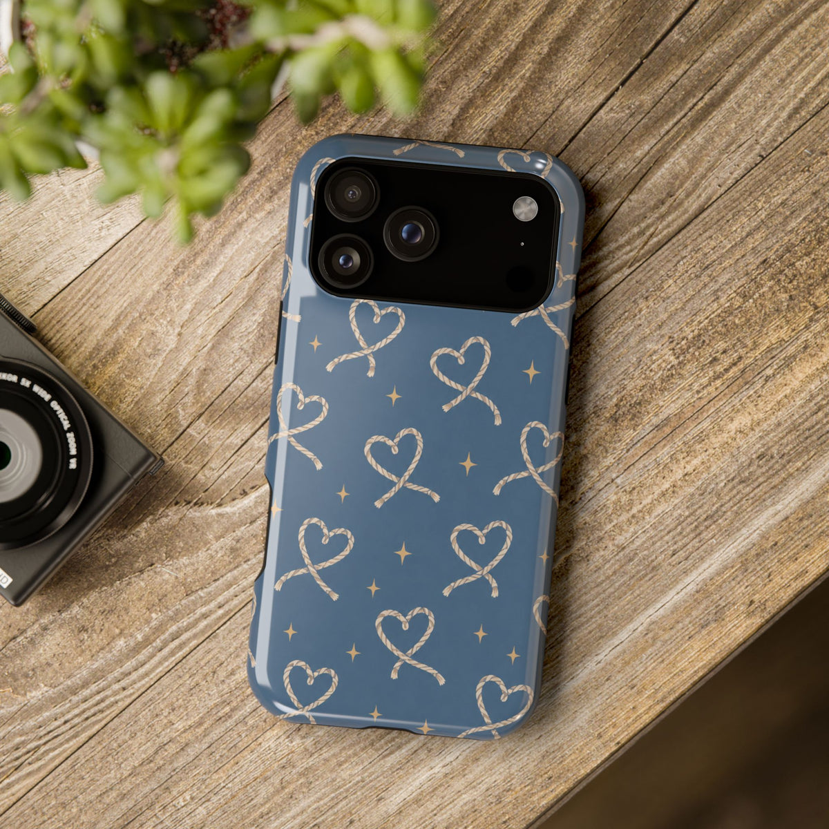 Lasso Hearts – Blue Western Heart MagSafe Phone Case, glossy wide-camera Pro Max model, rear view on a wooden surface