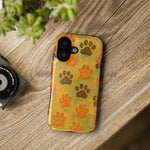 iPhone 12/13/14 case with orange and brown paw print pattern on wood surface showing camera size variant