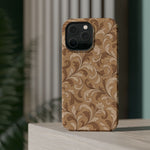 Saddle Scrolls – Tan Western Scrollwork MagSafe Phone Case, glossy square triple-camera Pro model, rear view on a tabletop