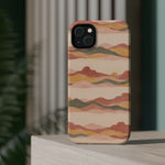 Sunset Trails – Desert Landscape MagSafe Phone Case, glossy diagonal dual-camera model, rear view on a tabletop