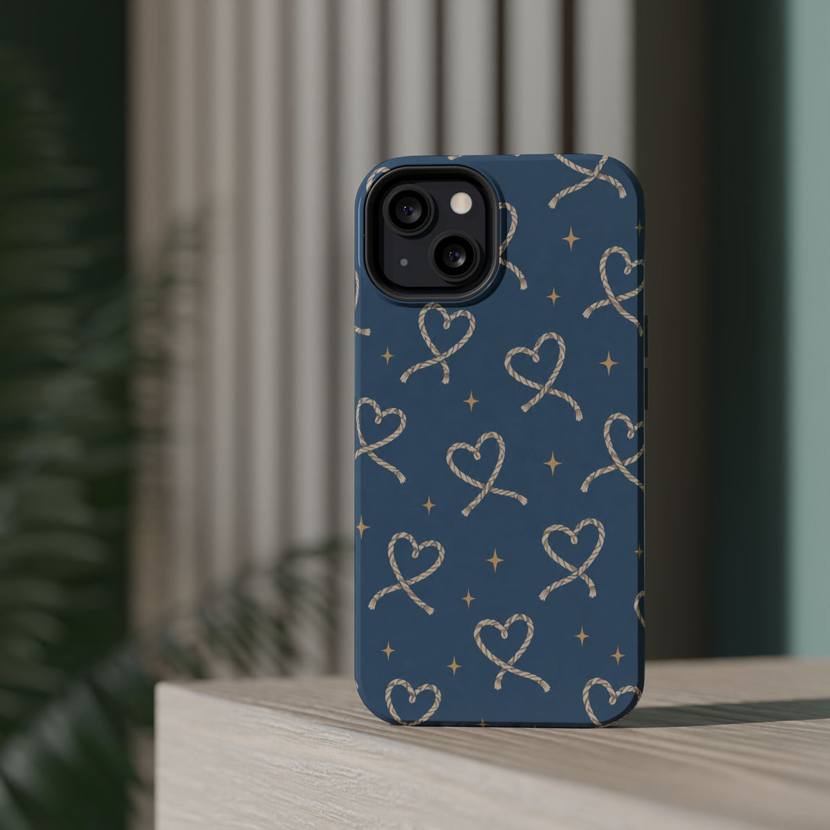 Lasso Hearts – Blue Western Heart MagSafe Phone Case, glossy diagonal dual-camera model, rear view on a tabletop