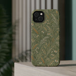 Golden Meadow – Sage Green Wildflower MagSafe Phone Case, glossy diagonal dual-camera model, rear view on a tabletop
