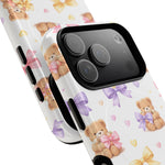 Close-up of smartphone with white case featuring teddy bears holding pink and purple bows, showing variant sizes