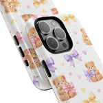 Two iPhone cases with teddy bear and colorful bow pattern, showing small and larger size variant