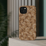 Saddle Scrolls – Tan Western Scrollwork MagSafe Phone Case, glossy diagonal dual-camera model, rear view on a tabletop