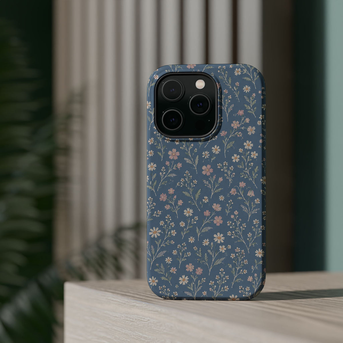 Denim Wildflowers MagSafe Phone Case, glossy square triple-camera Pro model, rear view on a tabletop