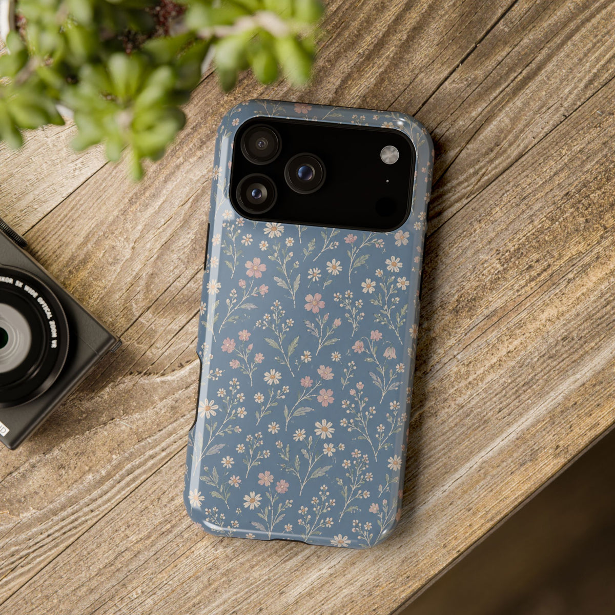 Denim Wildflowers MagSafe Phone Case, glossy wide-camera Pro model, rear view on a wooden surface