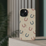 Prairie Horseshoes MagSafe Phone Case, glossy diagonal dual-camera model, rear view on a tabletop