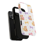 iPhone 14 Pro with two phone cases, black and white teddy bear design case showing variant size