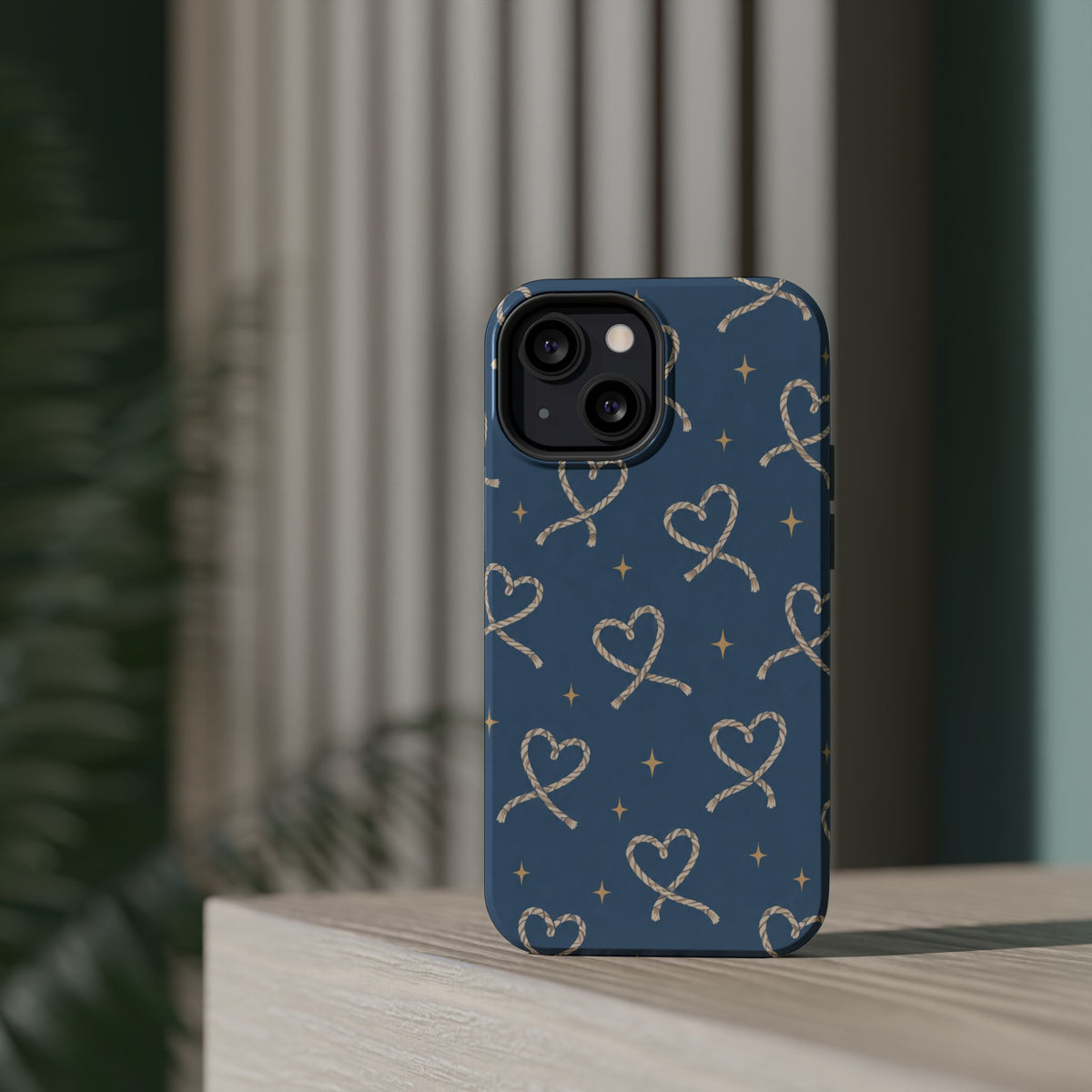 Lasso Hearts – Blue Western Heart MagSafe Phone Case, glossy diagonal dual-camera model, rear view on a tabletop