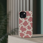Rose Cowprint – Pink Cow Print MagSafe Phone Case, glossy diagonal dual-camera model, rear view on a tabletop