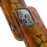 Close-up of two iPhone cases with lion face design, showing different sizes and camera cutouts