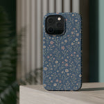 Denim Wildflowers MagSafe Phone Case, glossy square triple-camera Pro model, rear view on a tabletop