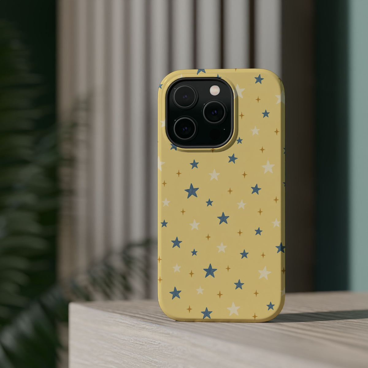 Prairie Stars – Yellow and Blue Star MagSafe Phone Case, glossy square triple-camera Pro model, rear view on a tabletop
