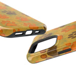 Close-up of phone cases with orange and brown paw print pattern on yellow background, showing size variants